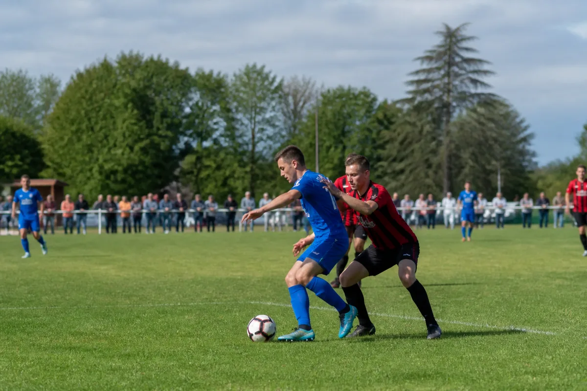 Match de football amateur dans la Marne avec joueurs et spectateurs en extérieur